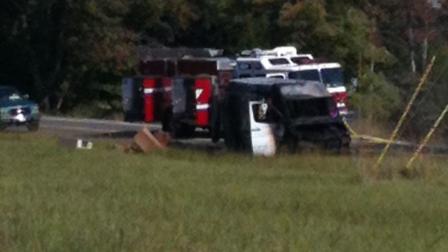 A fire truck next to whats left of a burned out FedEx vehicle.
