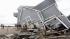 People stand next to a house collapsed from superstorm Sandy in East Haven, Conn. on Tuesday, Oct. 30, 2012.