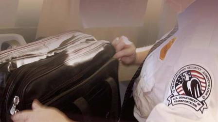 Transportation Security Administration screener at airport inspects bag