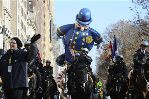 Mounted police lead a  policeman balloon as it...
