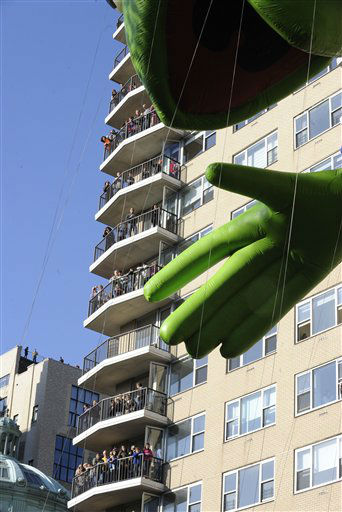 People fill balconies of an apartment building  as the Kermit The Frog balloon makes its way down New York's Central Park West at the start of the 86th annual Macy's Thanksgiving Day Parade,Thursday, Nov 22, 2012.