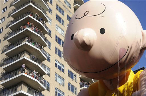 The Charlie Brown balloon passes people on...