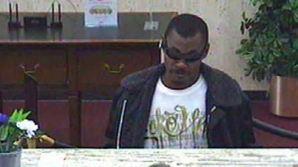 The image taken from a surveillance camera shows the suspect robbing the First Citizens Bank.