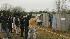 Media members gather outside a fence