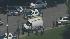 Police in a staging area search for a suspect