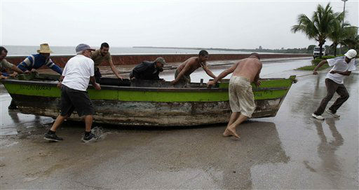 People remove a boat from the water ahead of the...