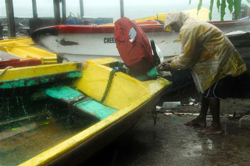 Fisherman Hubert Dowie works to secure his boat before the arrival of Hurricane Sandy in Port Royal, Jamaica, Wednesday, Oct. 24, 2012.