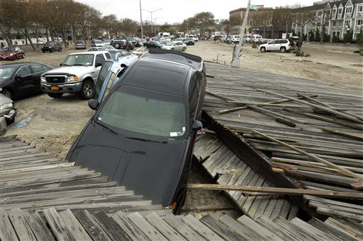 Pedestrians walk past the boardwalk and cars...