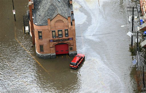 A firehouse is surrounded by floodwaters in the...