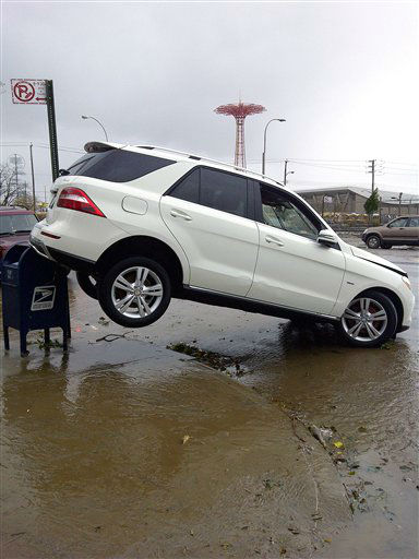 A car is upended on a mailbox on Surf Avenue in Coney Island, N.Y., in the aftermath of Sandy on Tuesday, Oct. 30, 2012.