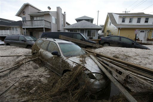 A car lies buried in sand and debris in the...