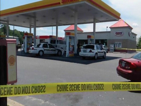 Officers investigate at a gas...
