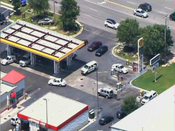 Officers investigate at a gas...