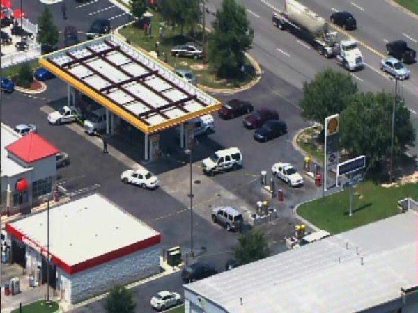 Officers investigate at a gas...