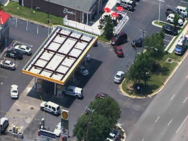Officers investigate at a gas...