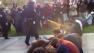 In this image made from video, a police officer uses pepper spray as he walks down a line of Occupy demonstrators sitting on the ground at the University of California, Davis on Friday, Nov. 18, 2011.