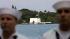 With sailors seen in the foreground, a flag flies at half staff on the Arizona Memorial during the 68th anniversary ceremony of the attack on Pearl Harbor