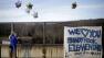 Kristin Hoyt, 18, of Danbury, Conn., ties a balloon to an overpass up the road from the Sandy Hook Elementary School, Saturday, Dec. 15, 2012, in Newtown, Conn. The massacre of 26 children and adults at Sandy Hook Elementary school elicited horror and soul-searching around the world even as it raised more basic questions about why the gunman, 20-year-old Adam Lanza, would have been driven to such a crime and how he chose his victims.