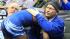 In this March 1, 2014 photo provided by Vanessa Schlueter, Minnesota wrestler Malik Stewart hugs Steve McKee moments after losing his Class 3A 120-pound high school wrestling title match to McKees son, Mitchell, in St. Paul, Minn. In this March 1, 2014 photo provided by Vanessa Schlueter, Minnesota wrestler Malik Stewart hugs Steve McKee moments after losing his Class 3A 120-pound high school wrestling title match to McKees son, Mitchell, in St. Paul, Minn.
