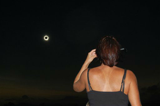 In this photo provided by Tourism Queensland, a woman watches a total solar eclipse at Lakeland in Queensland state, Australia, Wednesday, Nov. 14, 2012.