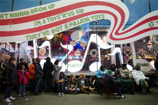 Shoppers wait in line for the 8 p.m. opening of...