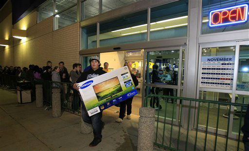 Christian Adorno, 13, walks out of a Best Buy with a 40-inch television Friday, Nov. 23, 2012, in Mayfield Heights, Ohio. The store opened at 12 a.m. on Friday.