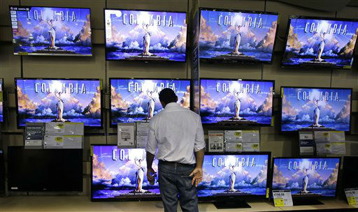 A shopper looks at televisions at a Best Buy...