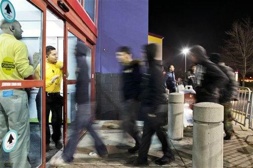 Store employees open the doors at midnight to a...