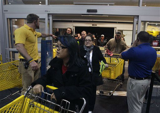 Best Buy electronics store employees, at far right and left, open doors to shoppers for a Black Friday sale that began at midnight, in Broomfield, Colo., early Friday Nov. 23, 2012.