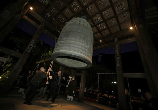 Worshipers strike a giant bell to celebrate the...