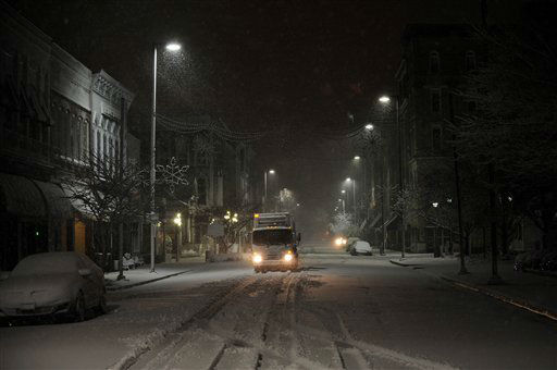 A city waste management truck drives on Broadway...